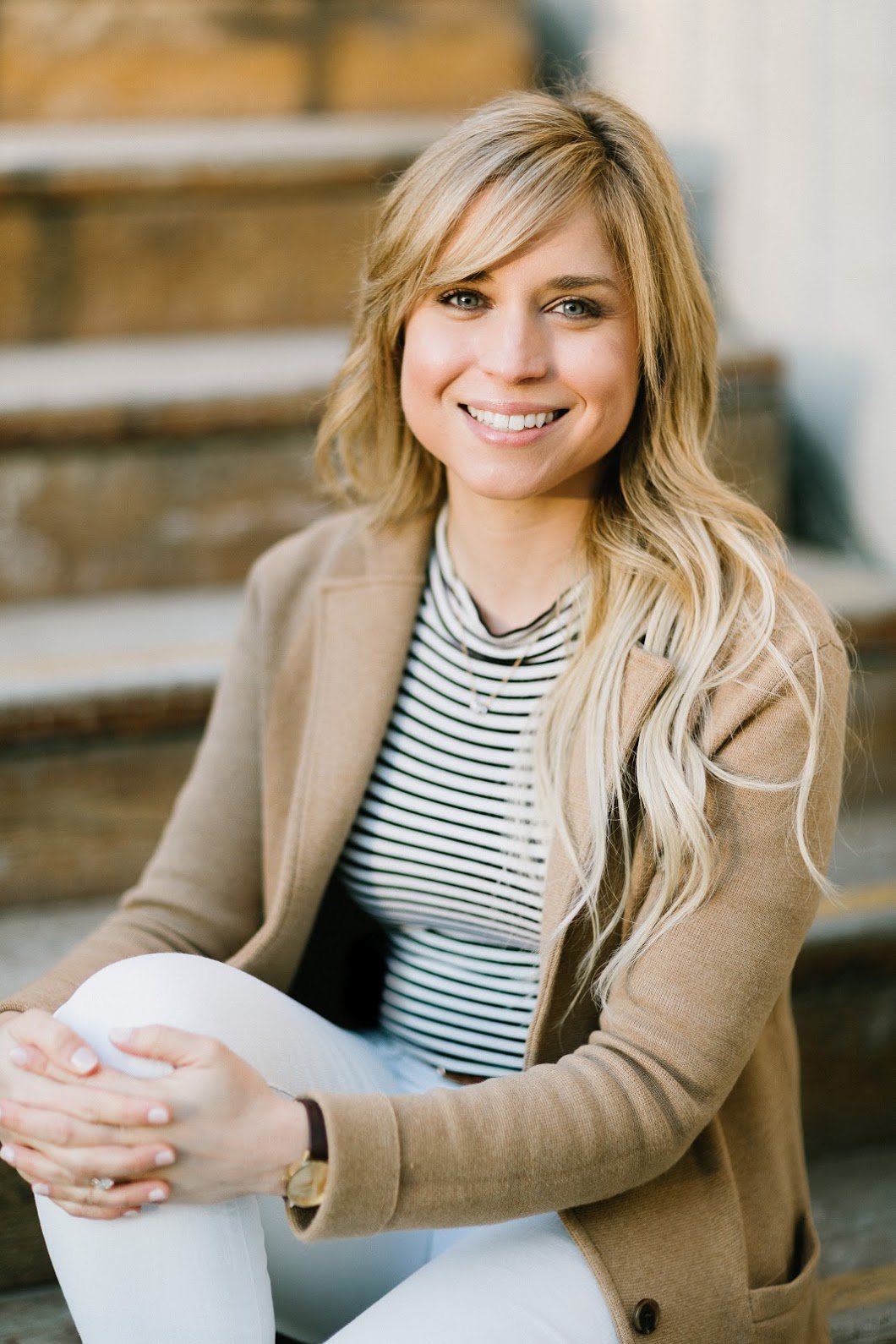Dr. Laura-Beth Fitzpatrick, licensed clinical psychologist in San Diego, smiling and seated on wooden steps