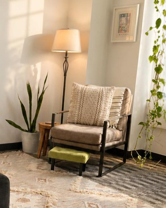 A corner of the therapy office with an armchair, a floor lamp and plants in warm light